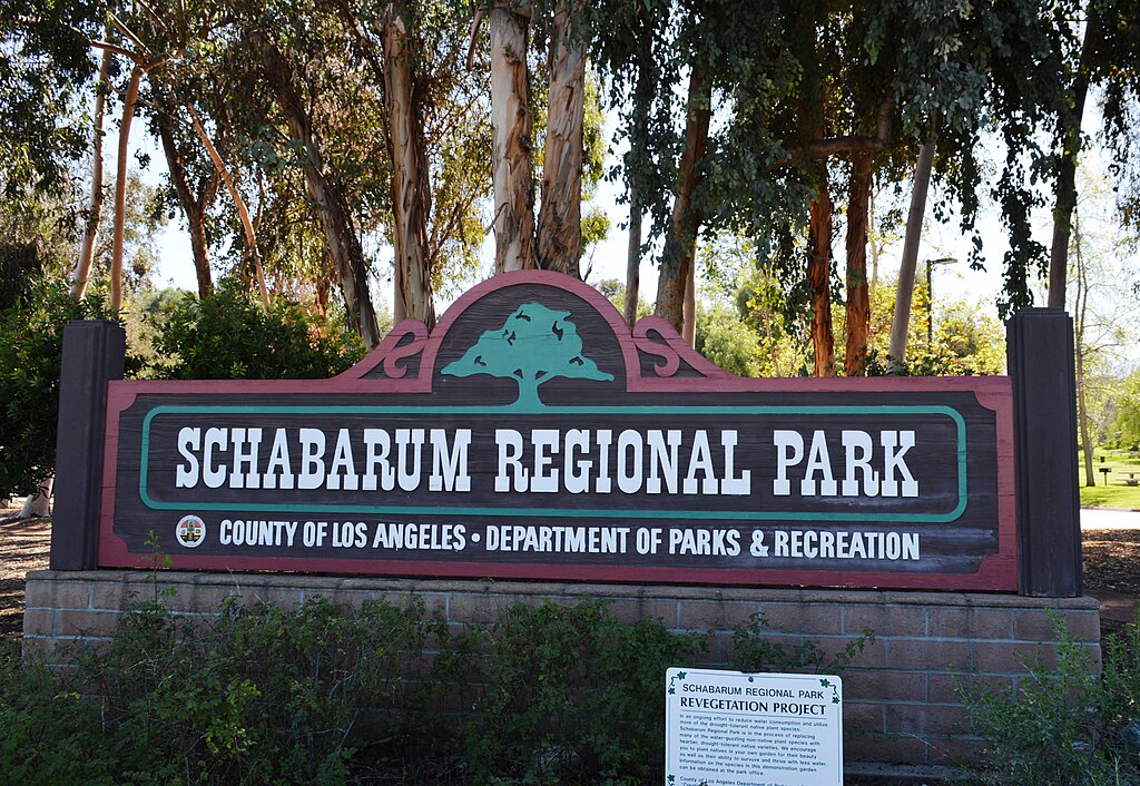 Entrance sign for Schabarum Regional Park in Rowland Heights, California, surrounded by trees and greenery.