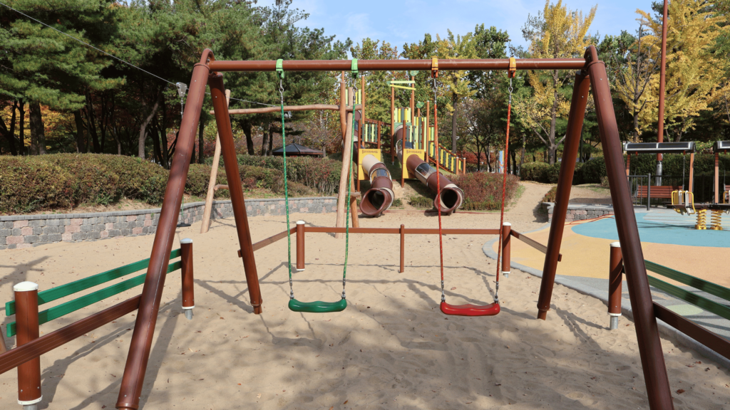 a playground with swings and slides in the middle of a park
