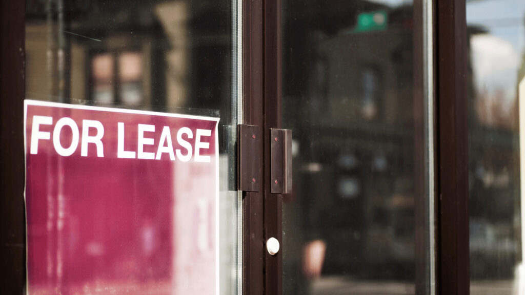A for lease sign is displayed in the window of a building after the tenant decided to terminate long-term lease