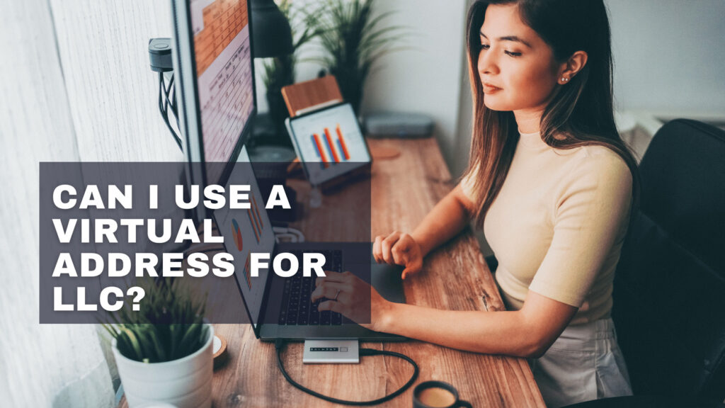 A person works at a desk with a laptop and two monitors displaying charts and graphs, with the title " Can I use a virtual address for LLC?